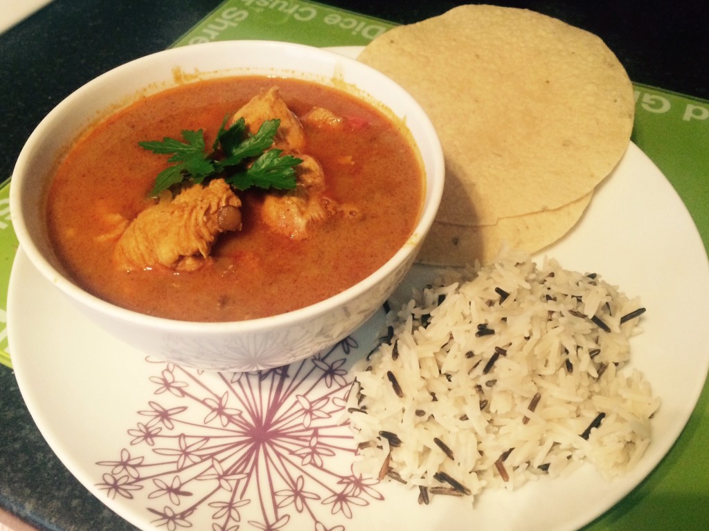 A bowl of curry with wild rice and poppadoms