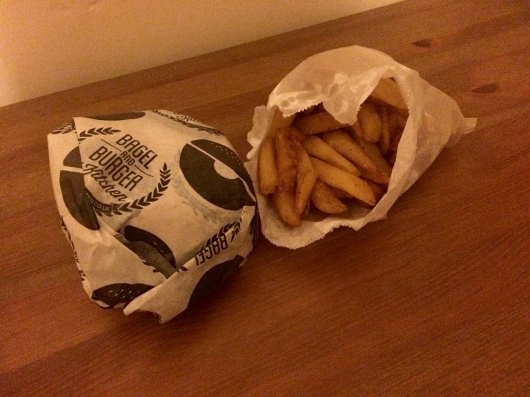 Burger wrapped up, with fries in paper bag