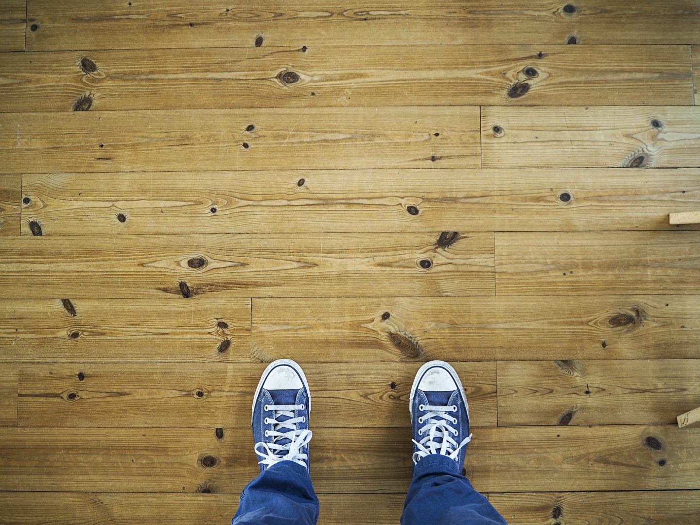 Male feet standing on wooden flooring