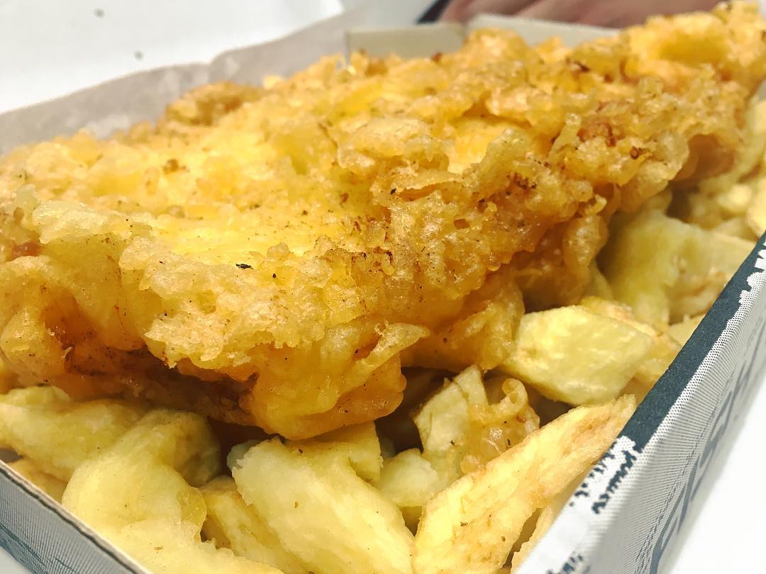 Close-up shot of battered fish and chunky homemade chips