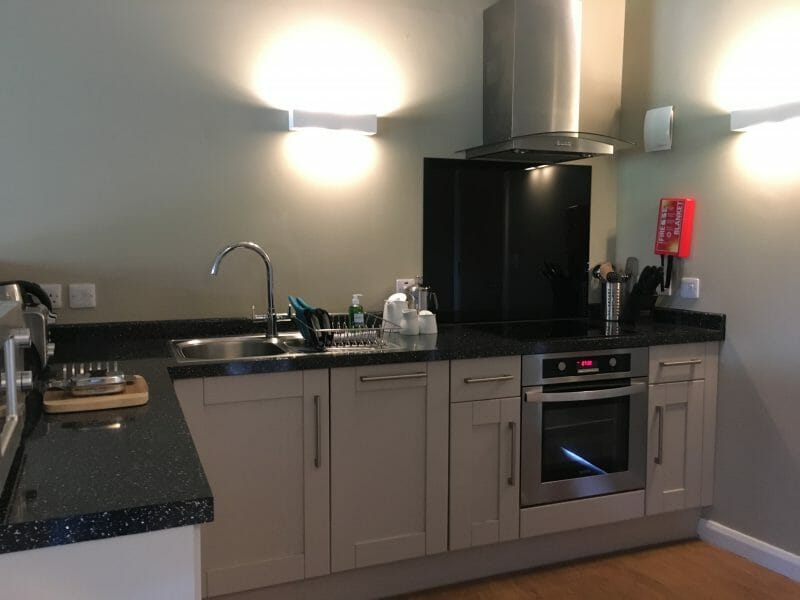A kitchen with worktop space, cupboards, an oven and a hob at Bluestone Wales