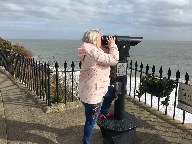 Peering through a telescope on Tenby South Beach