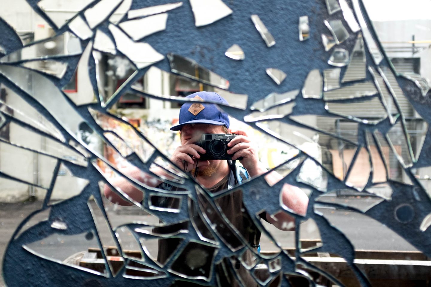 A portrait photo (selfie) of Thomas Mathys (the author of the Swiss cheese fondue recipe in my Eat Like a Local guest post series) taken in a shattered mirror.