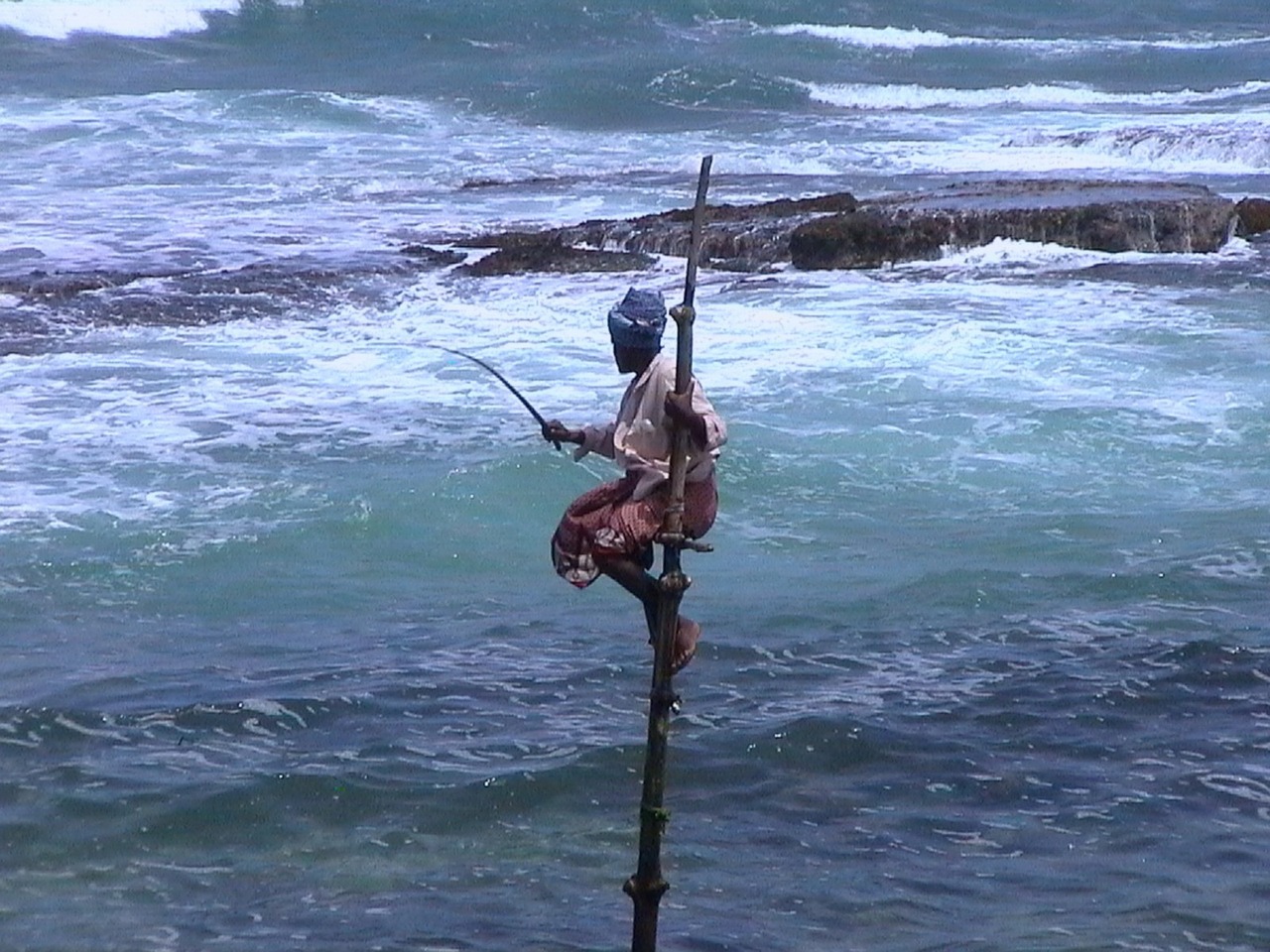 Fishing in Sri Lanka, perched on a tall stick looking out over the ocean