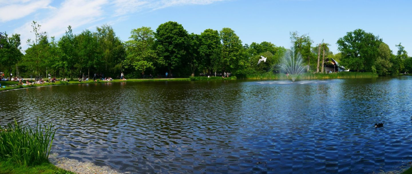 A panoramic view over the lake at Amsterdam Vondelpark, with the water fountain visible in the distance.