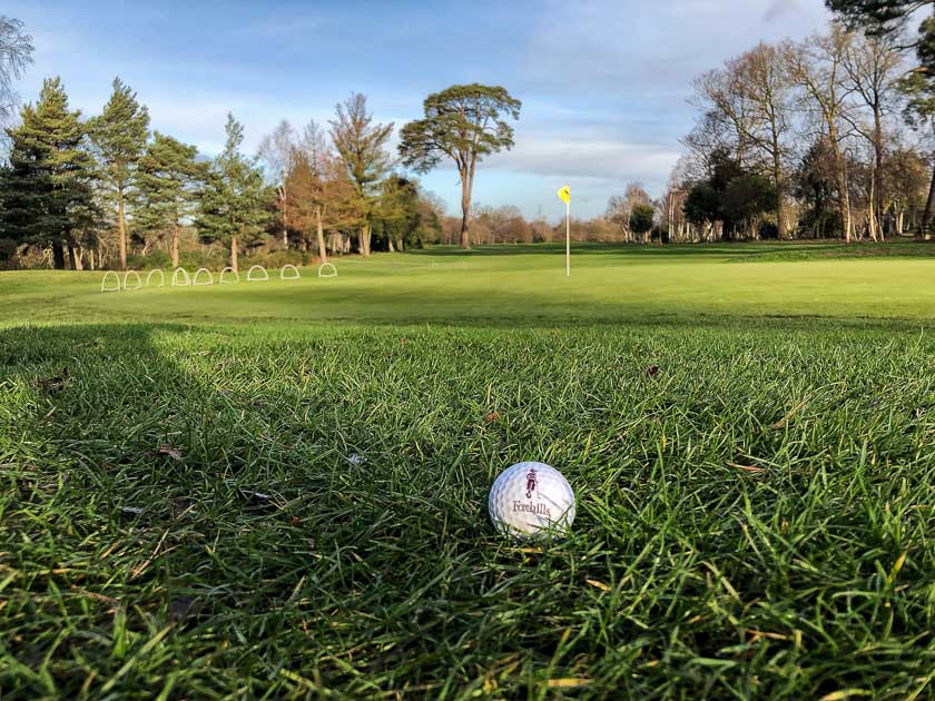 A close-up of a golf ball sitting on the course at Foxhills Golf and Country Club in Surrey, England