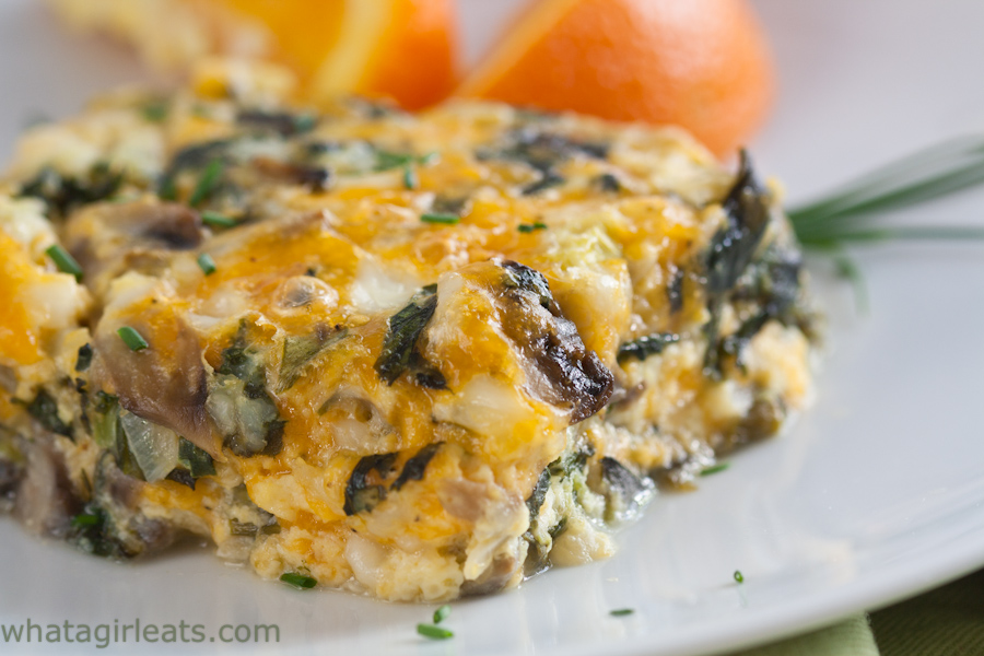 Cheesy spinach and mushroom casserole, served on a plate.