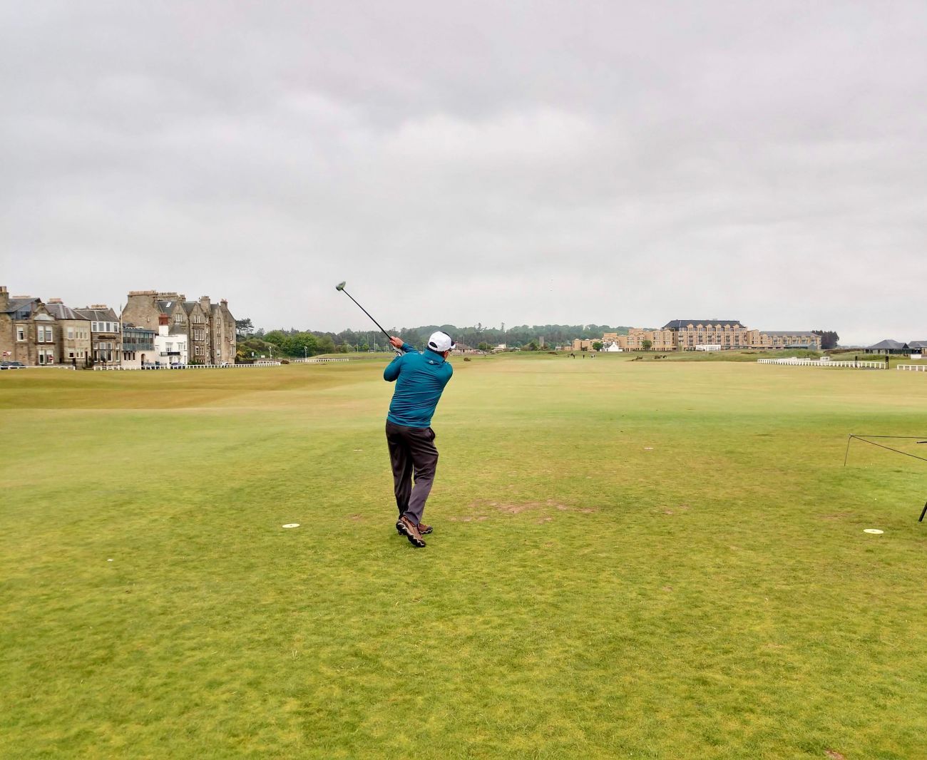 A man hitting a golf ball at Old Course in St. Andrew's, east Scotland.