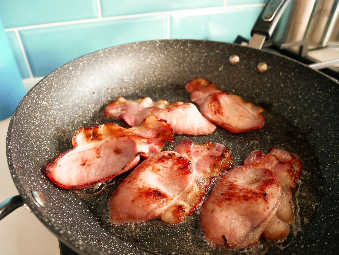 Edwards of Conwy bacon sizzling in a frying pan