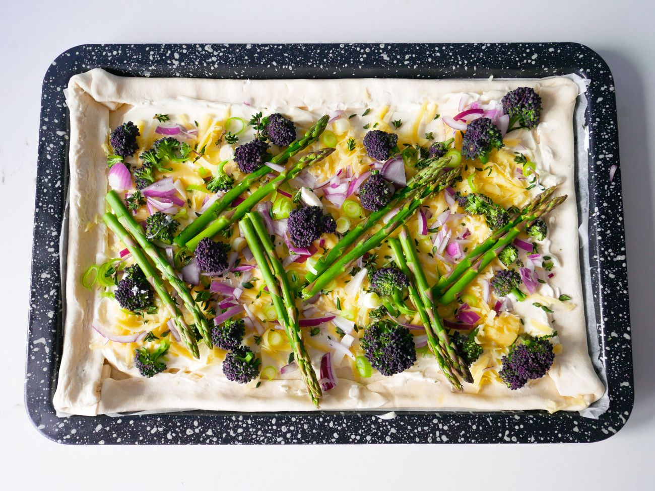 Puff-pastry tart topped with seasonal spring veg, uncooked