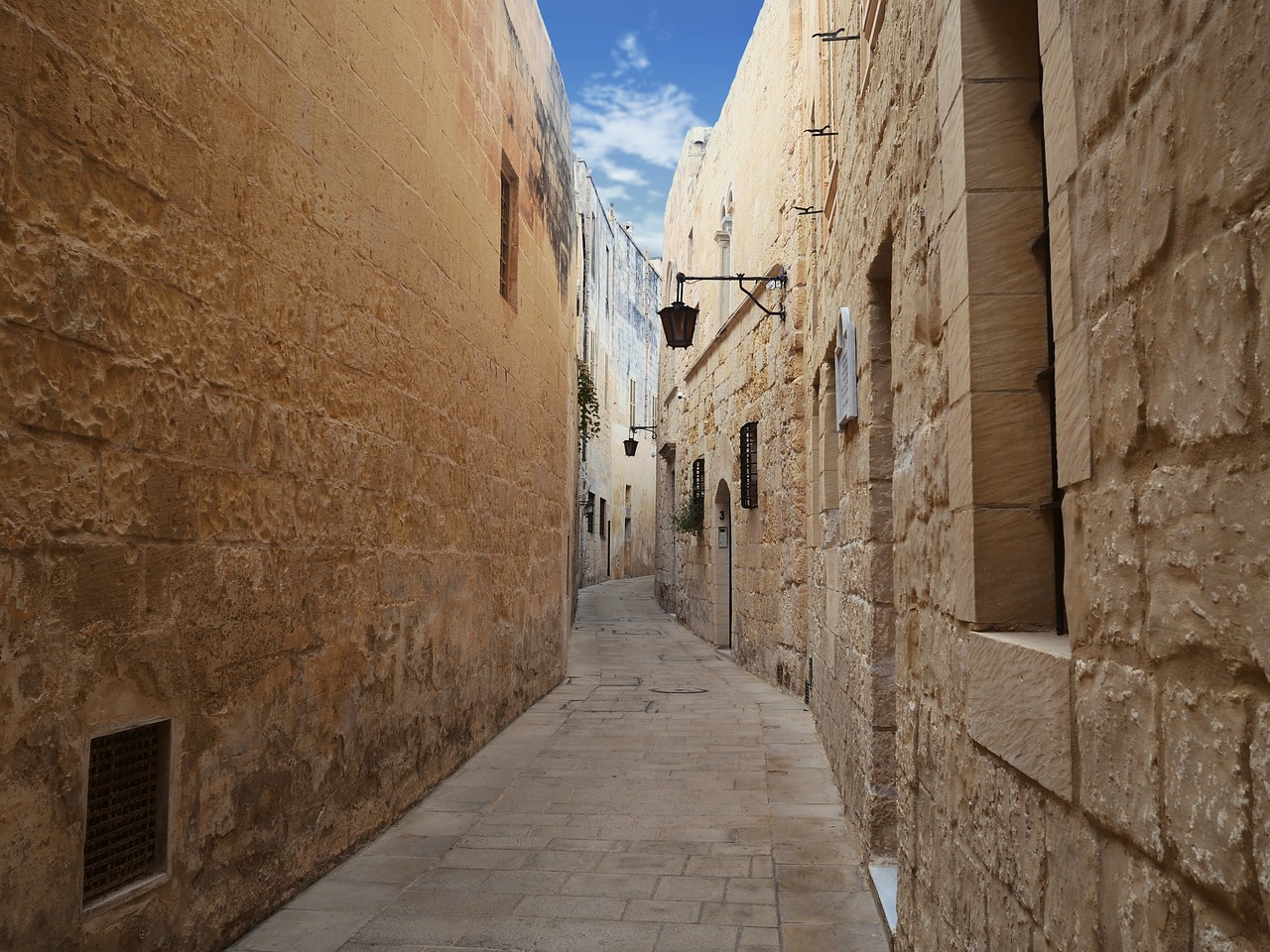 A narrow, winding street in Mdina, the old capital city of Malta.