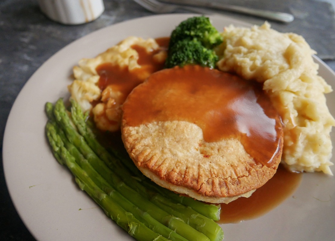 Holland's Pies Cheese and Onion Pie with gravy, mash and veggies