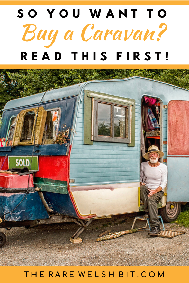 An old man sitting outside a caravan.