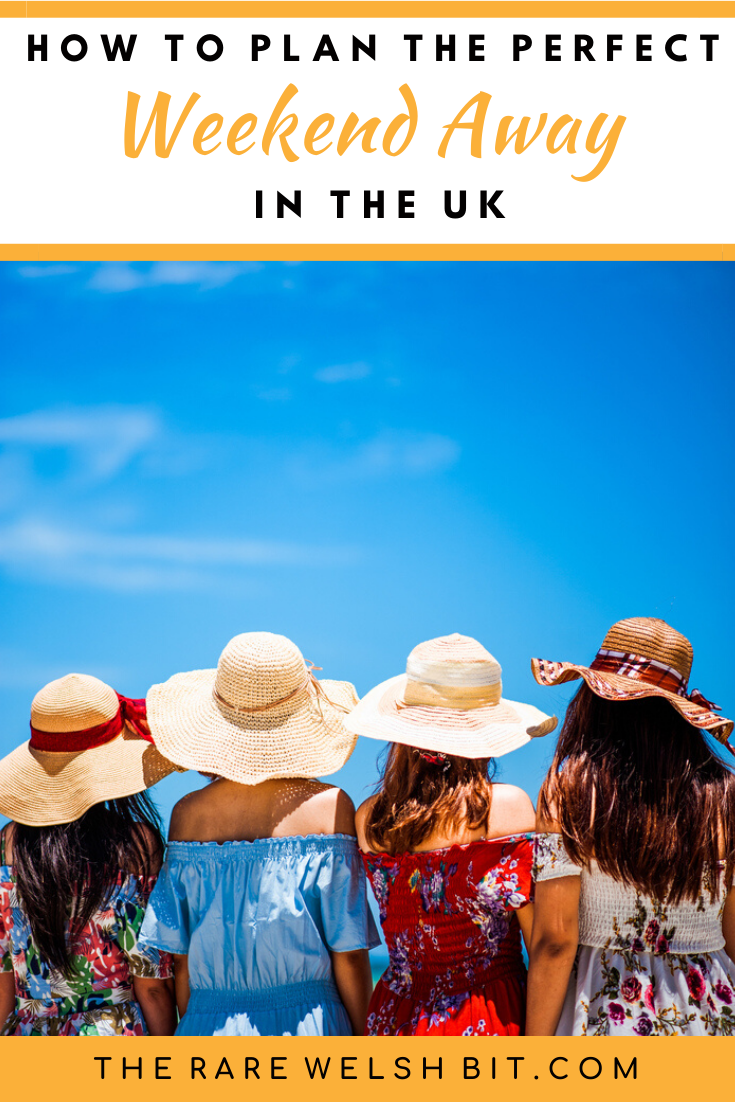 Four friends wearing floppy hats, looking out at a bright blue sky while on a weekend away in the UK
