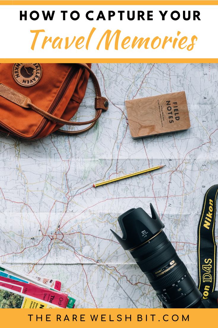 A map with a DSLR camera, travel guides, camera bag and notebook on top of it.