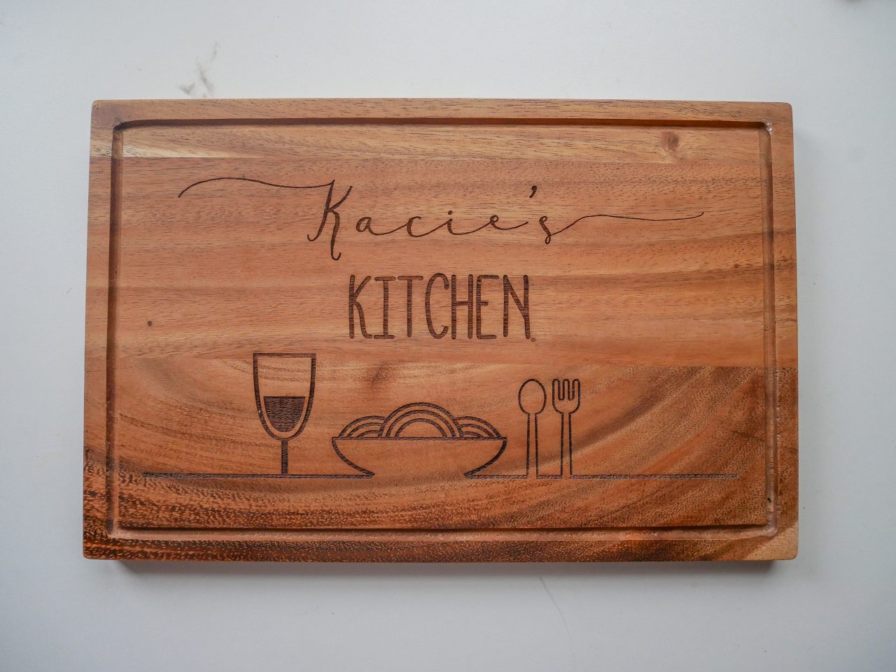 Engraved chopping board reading, 'Kacie's Kitchen'
