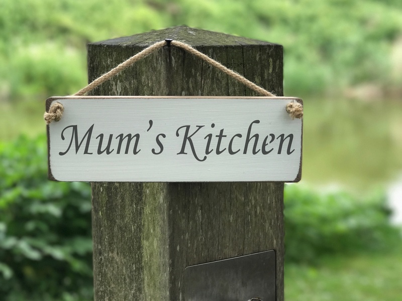 Mum's kitchen sign hanging on a wooden post
