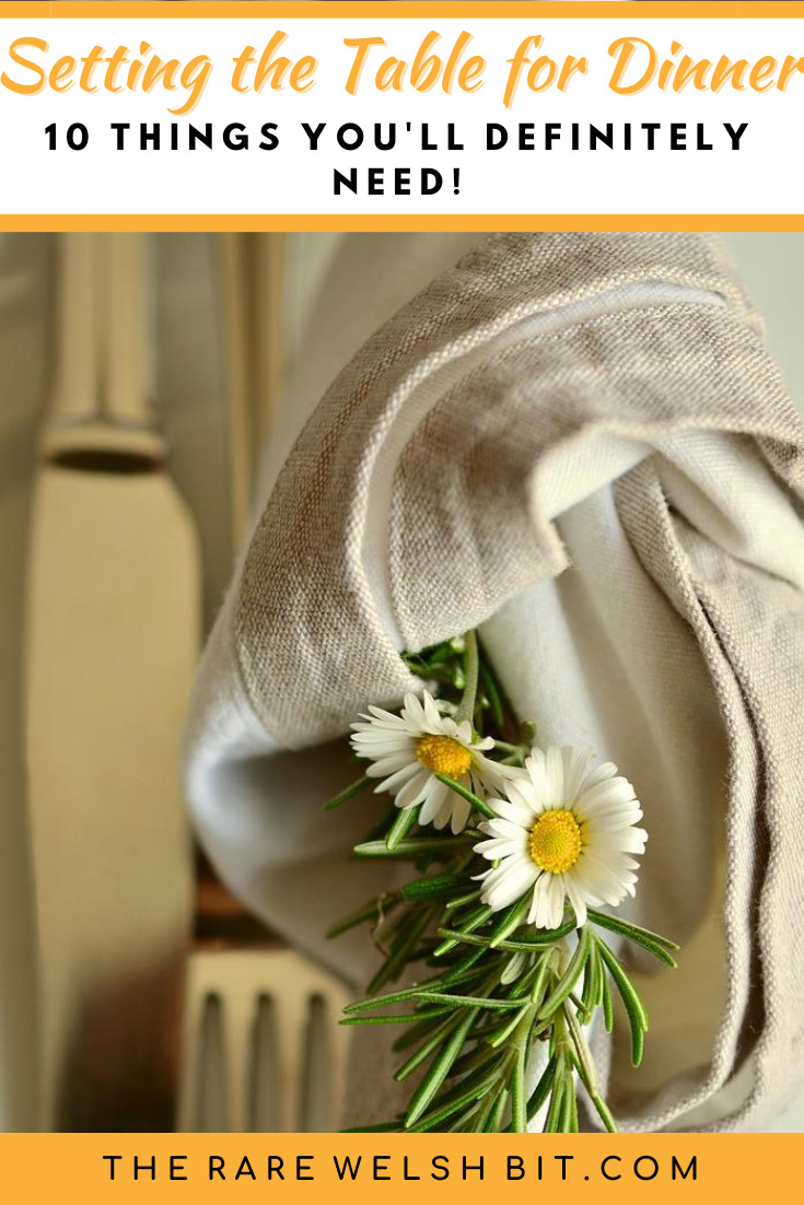 A daisy rolled up into a napkin, next to a knife and fork
