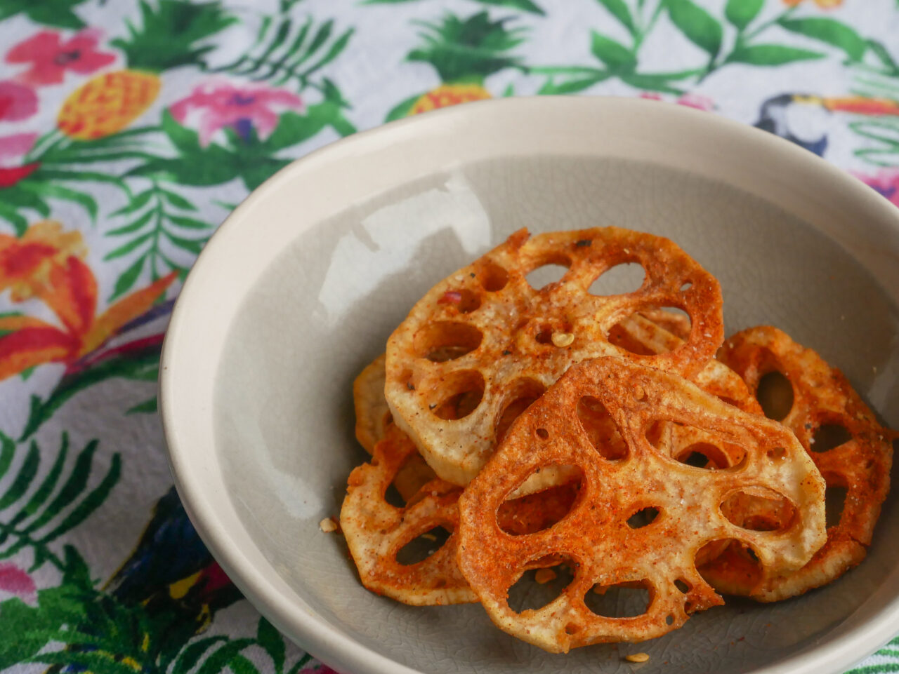 Lotus root crisp in a bowl on a tropical-inspired background