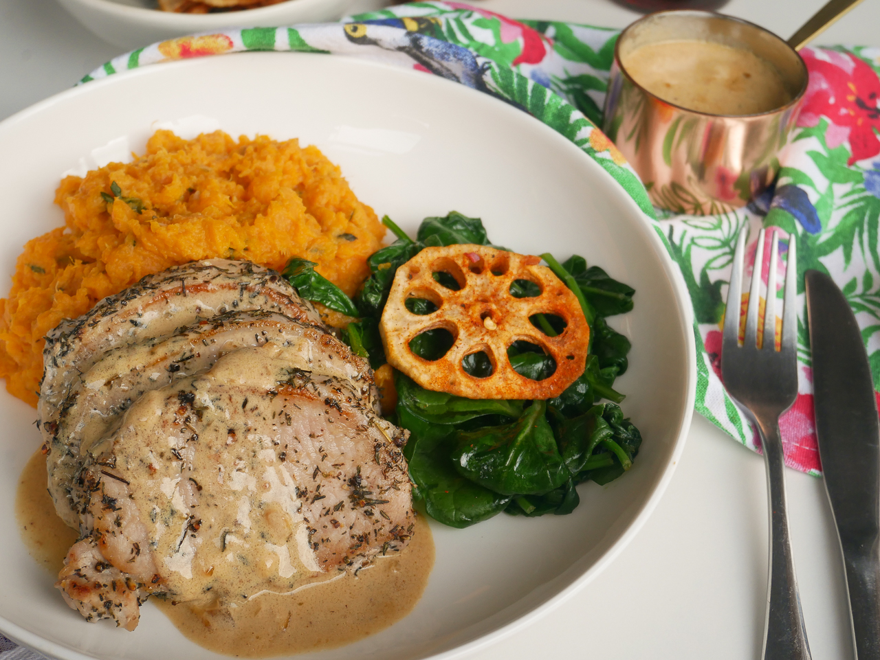 Pork medallions with spinach, sweet potato mash and lotus root crisps, with sauce in background