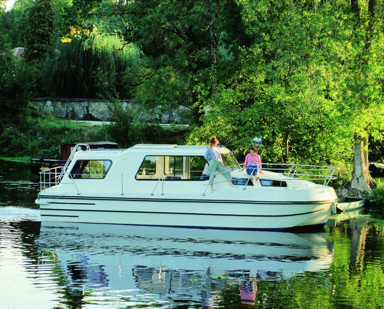 Canal boat hire could be an option for your 2021 UK staycation. This photo shows a canal boat sailing down the Riviera.