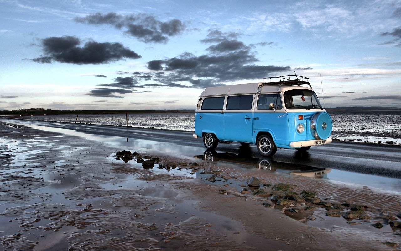A blue campervan on a beach