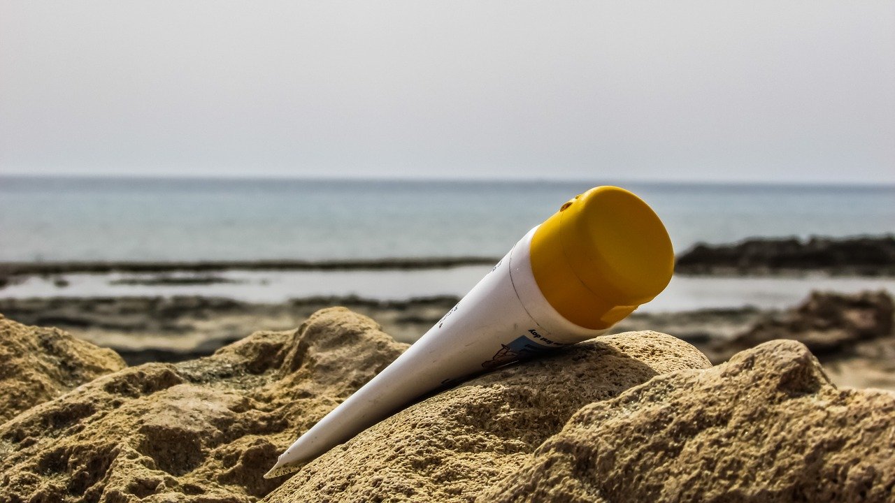 Suncream lying on the sand at the beach