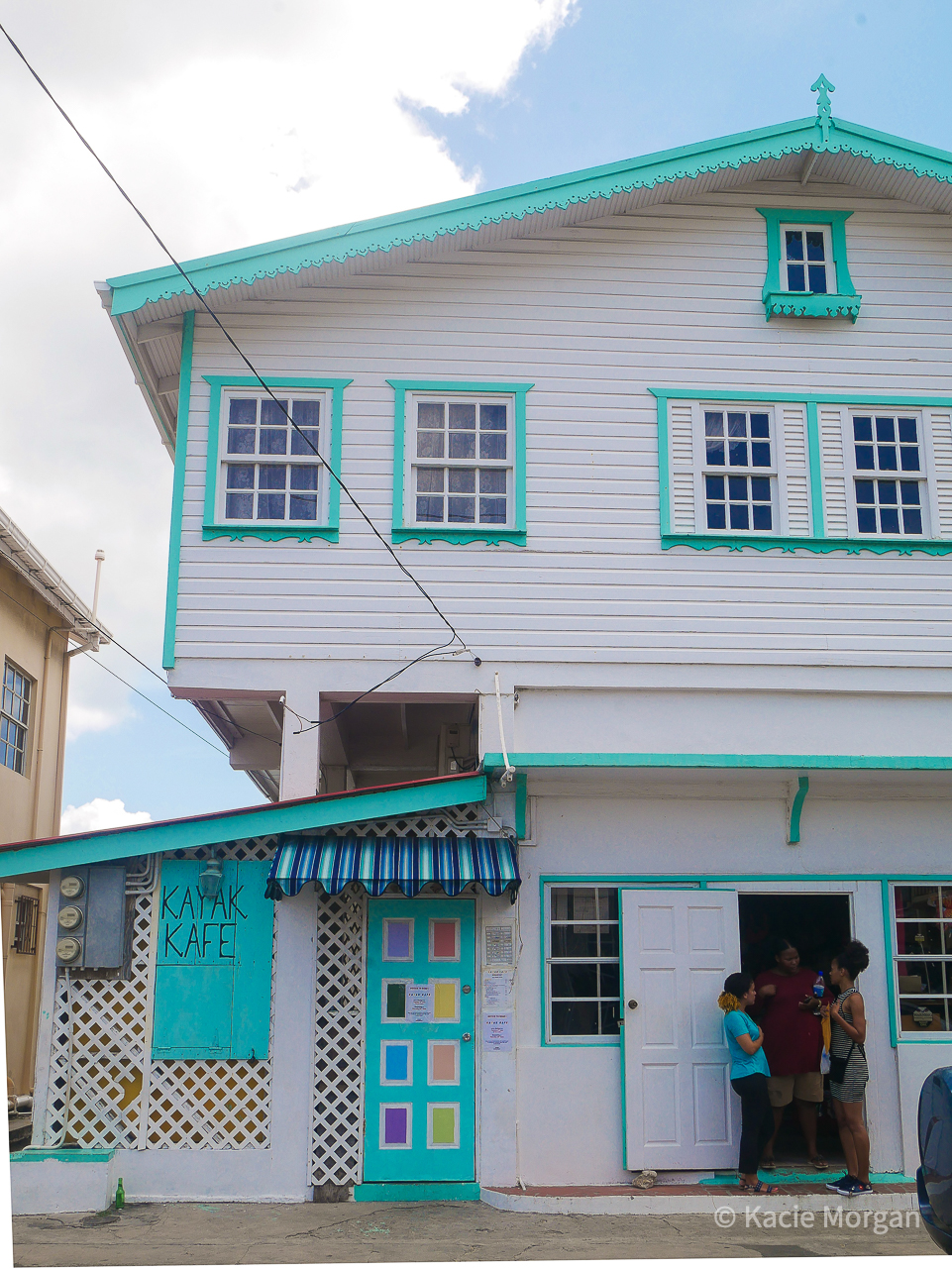 A group of girls stood chatting in the doorway of Kayak Kafe in Carriacou, Grenada