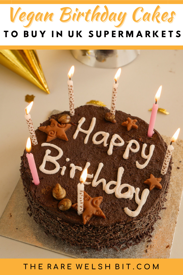 A chocolate 'happy birthday' cake finished with lit candles waiting to be blown out