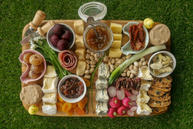 Spring charcuterie board using seasonal ingredients, on artificial grass