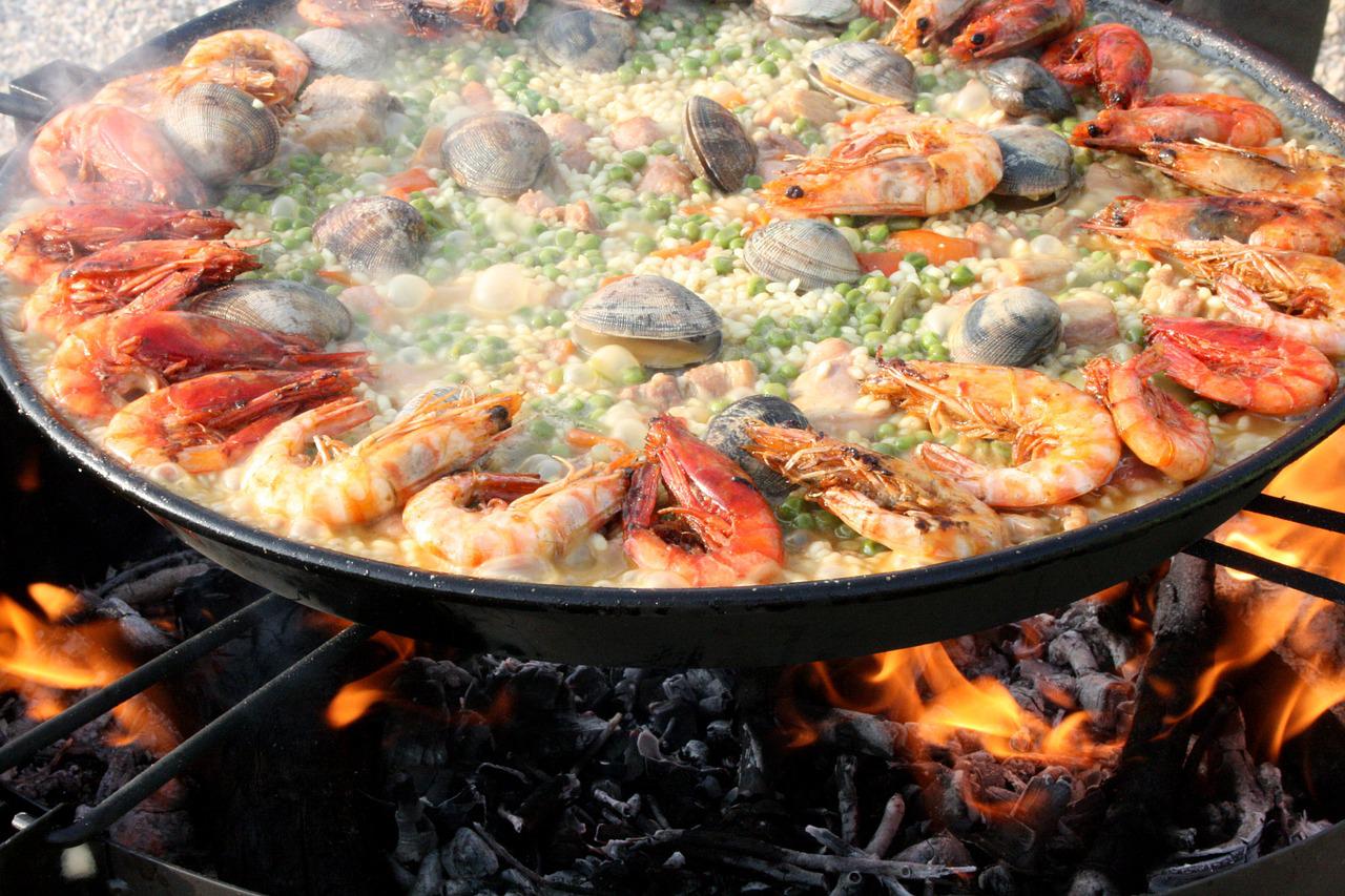Big pan of Spanish paella on the flames