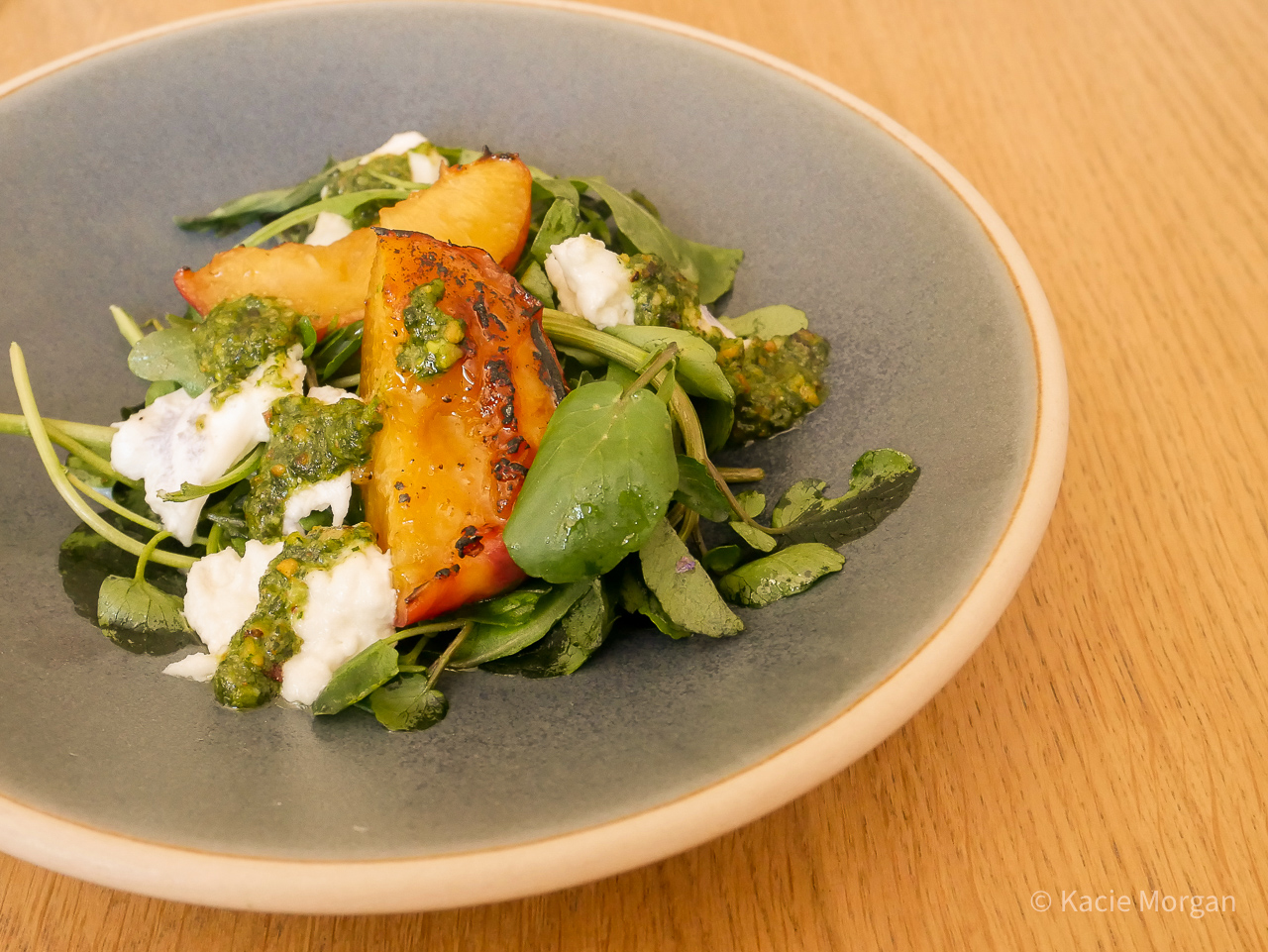 Maple sugar charred nectarine with salad greens, mozzella, pistachio pesto, and maple vinaigrette