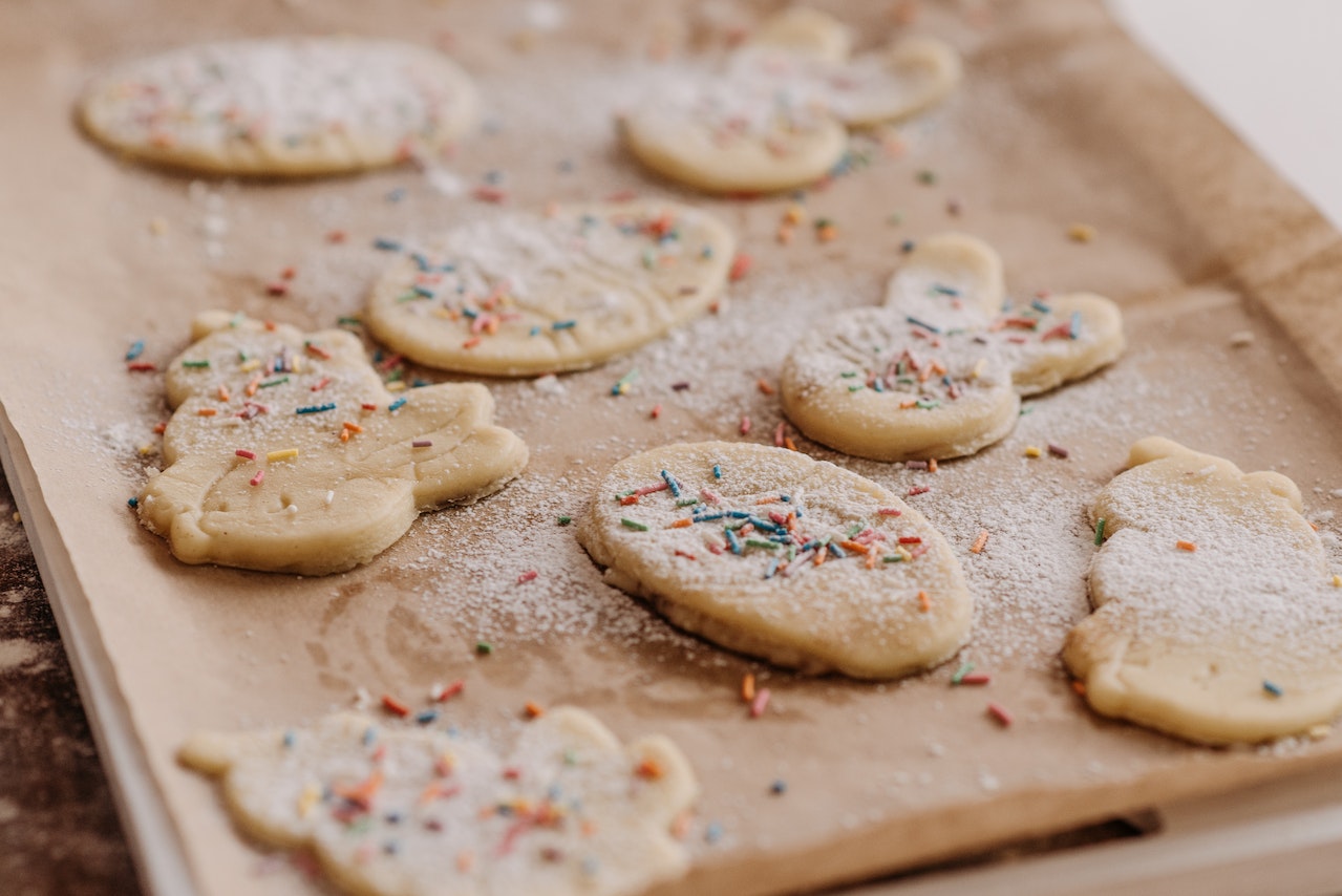 Sugar cookies covered in coloured strands, on a baking tray