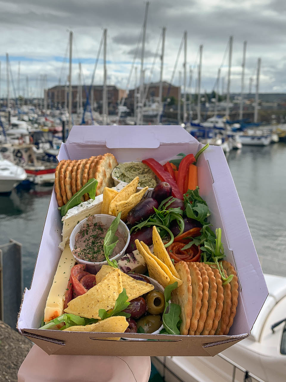 Grazing lunch box from The Cheesy Cow, with Milford Marina in the background