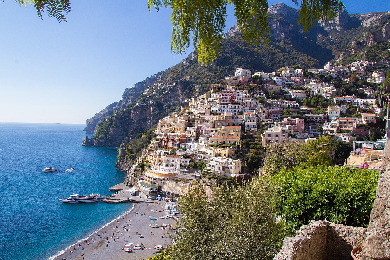 Houses stretched across a hillside in the Amalfi Coast, with the scenic beach lying below.