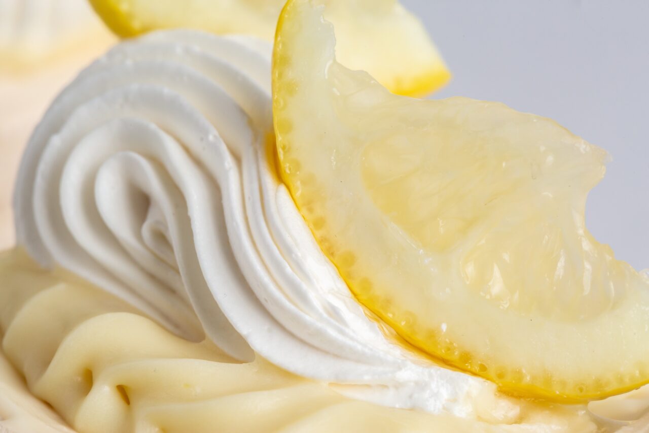 Close-up of lemon mousse with cream and fresh lemon