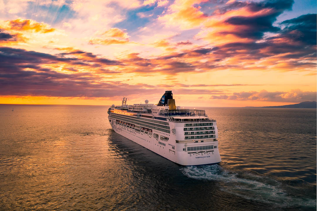 Cruise liner sailing across the sea, during sunset