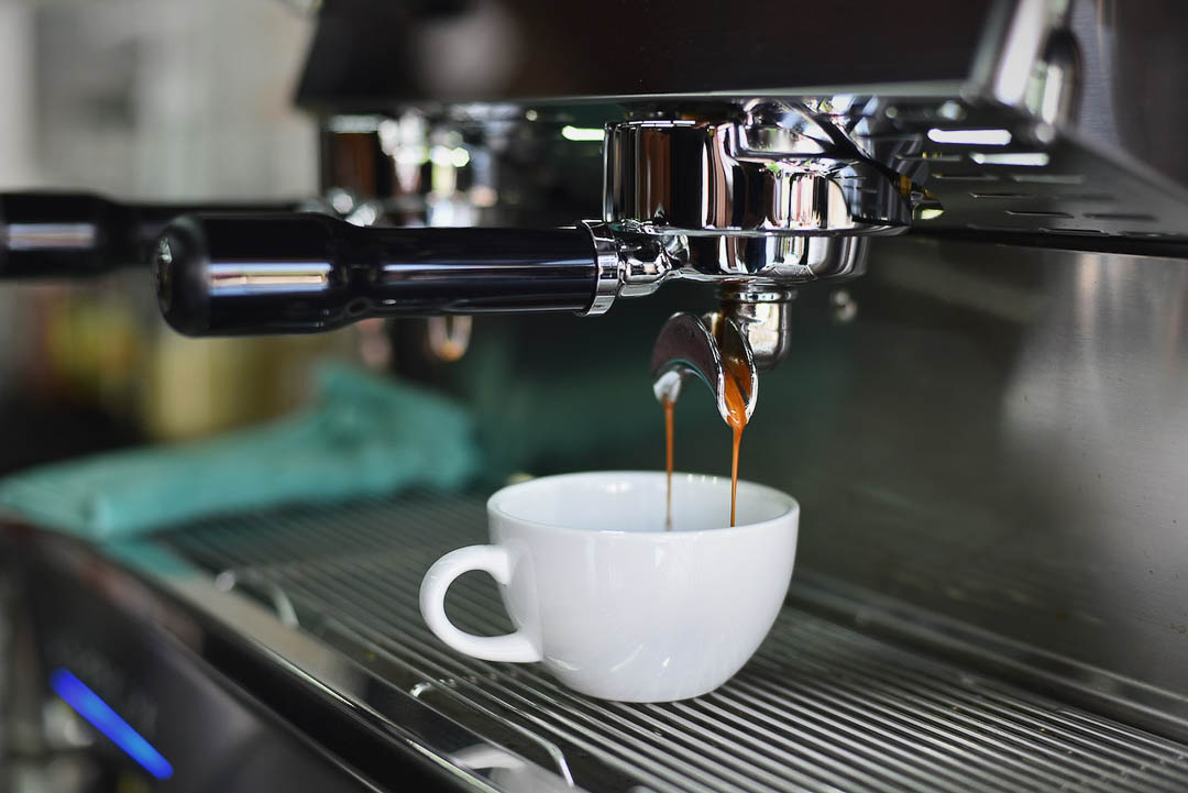 Coffee being poured into a cup, from a coffee machine