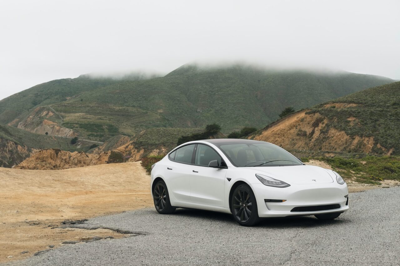 White Sedan parked up overlooking a fog-covered mountain