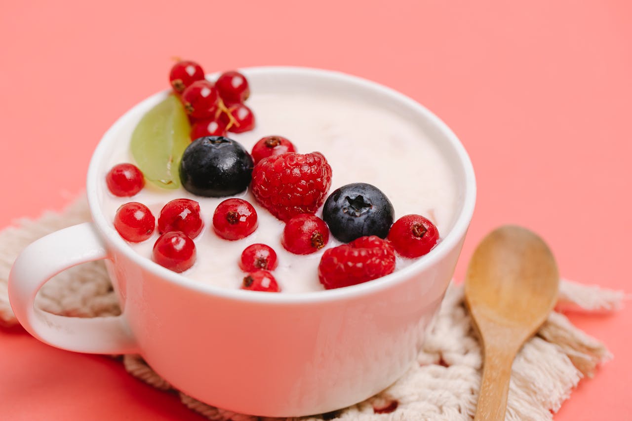 Greek yoghurt in a mug topped with fresh berries and a grape