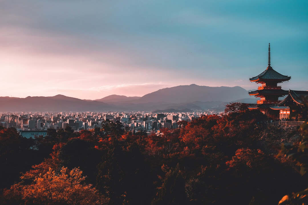 Pagoda surrounded by trees, with skyscrapers in the distance