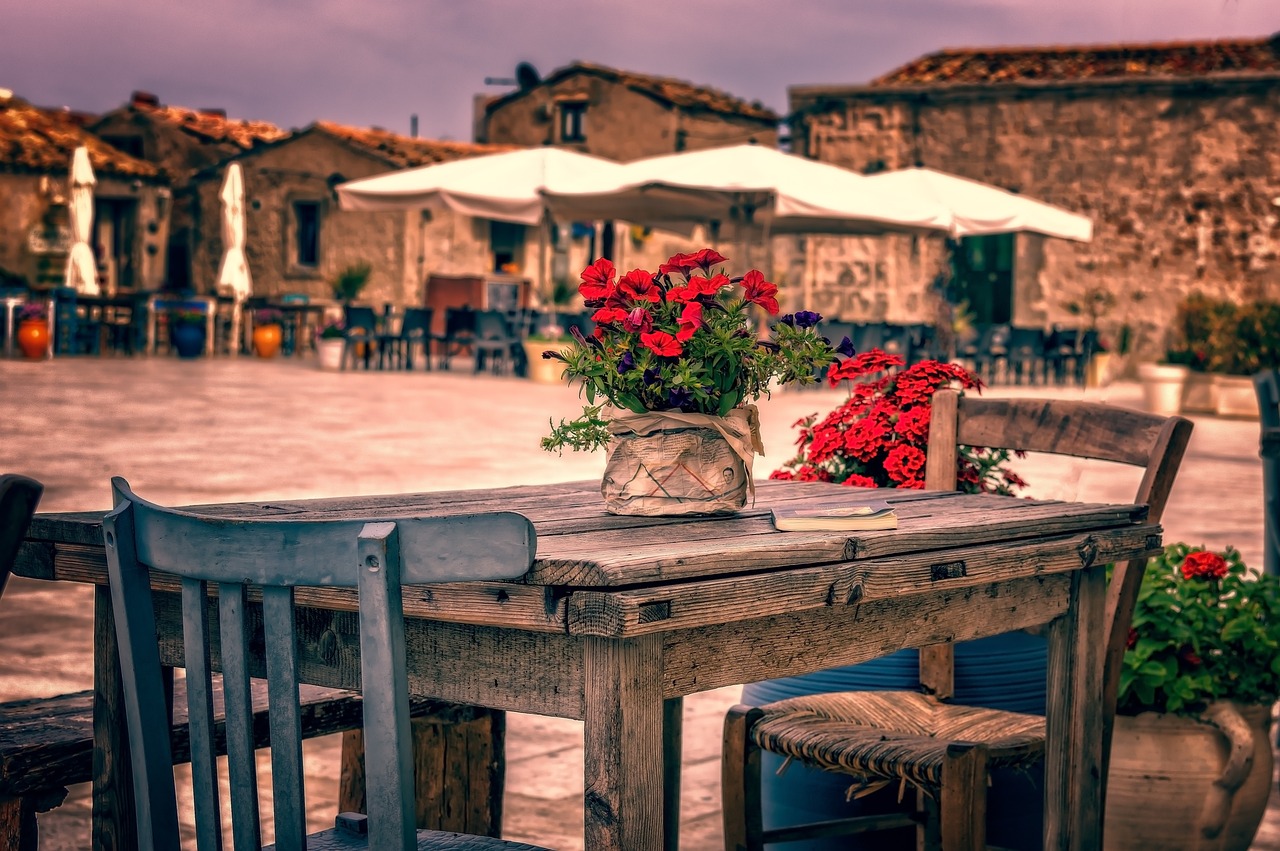 A book on a wooden table in an outdoor dining area.