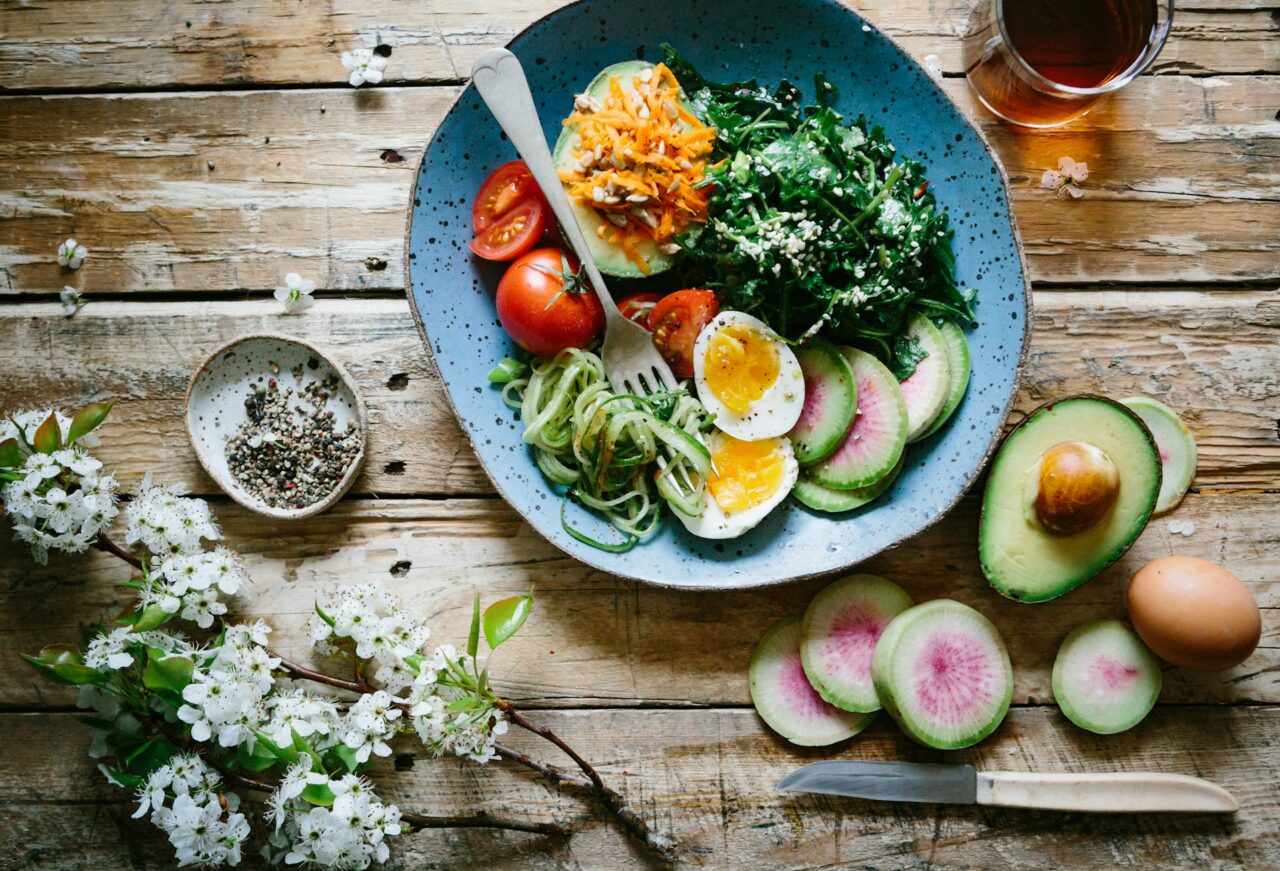 Boiled egg with vegetables and tomatoes on a blue plate