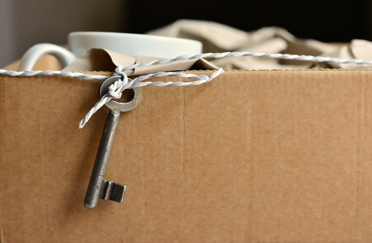 A key on string next to a brown cardboard box