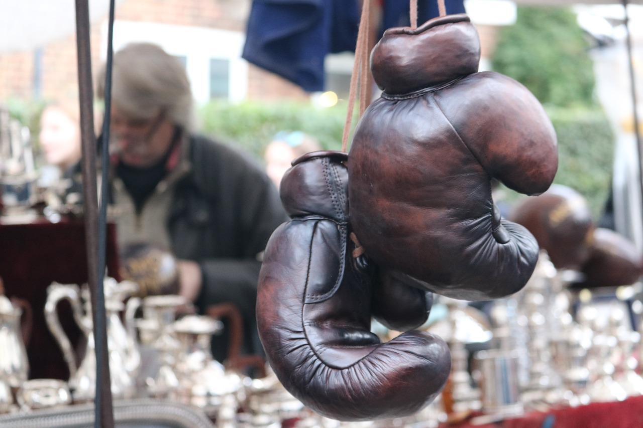 Old worn leather boxing gloves, hanging up on a stall