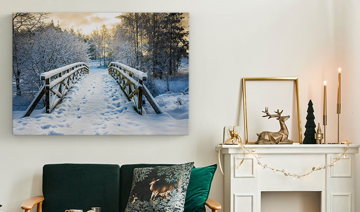 A snowy travel scene on a canvas print on a wall, in a lounge decorated with a festive theme