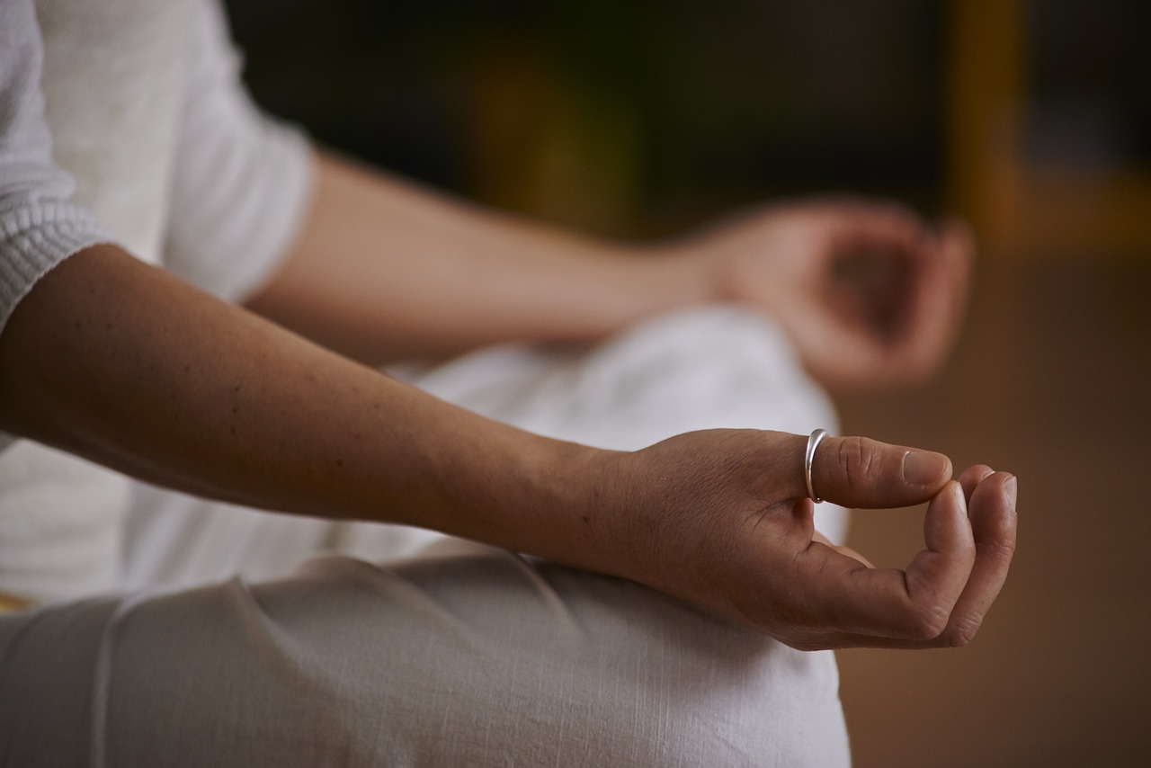 A female sitting cross-legged in meditative yoga pose