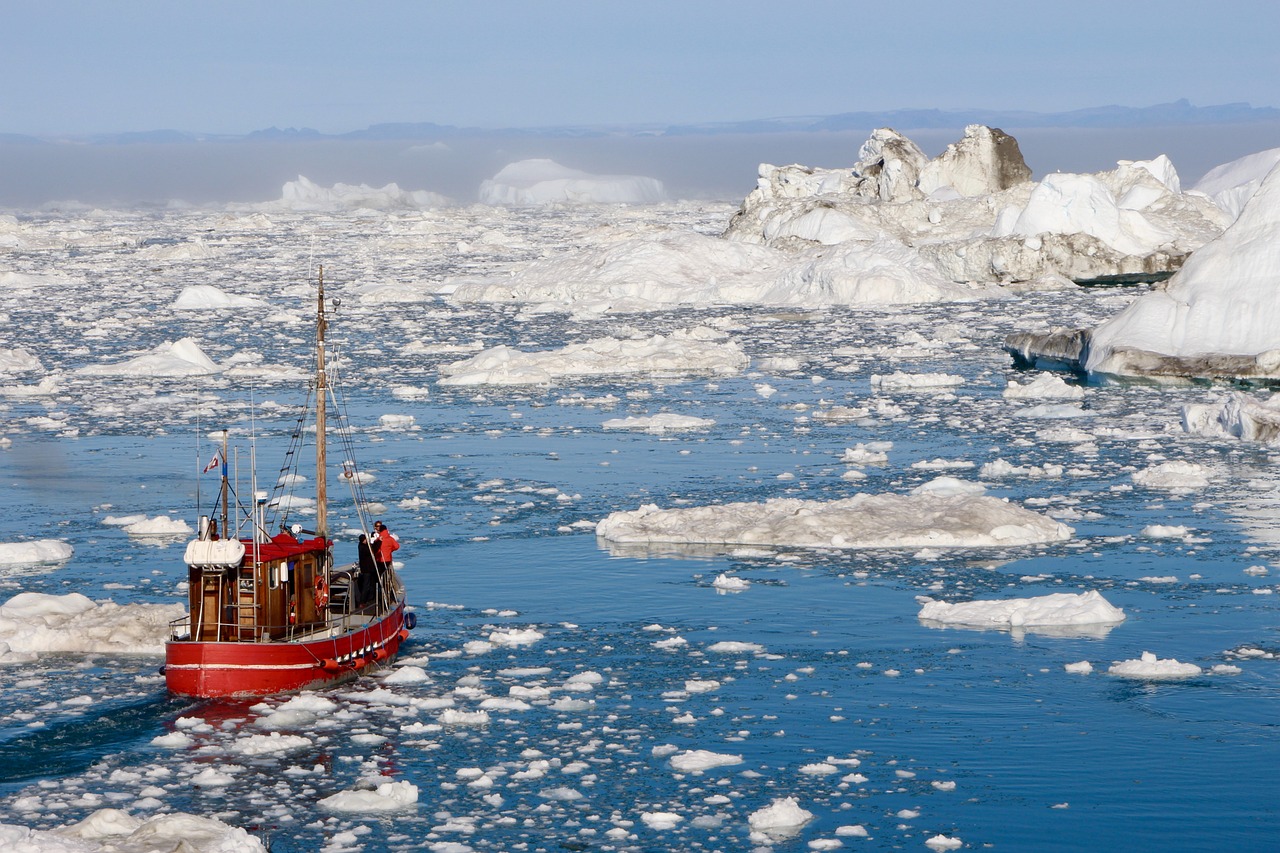A small red shop passing by some small icebergs,
