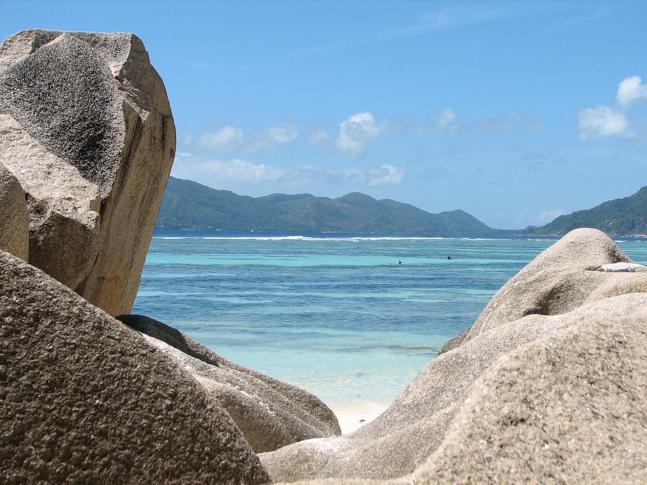 A beach scene framed by some rocks in the Seychelles