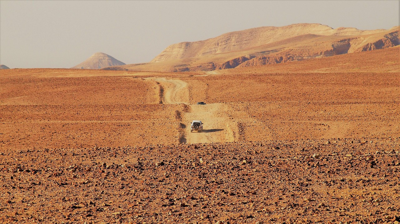 A car driving through the desert on a track.